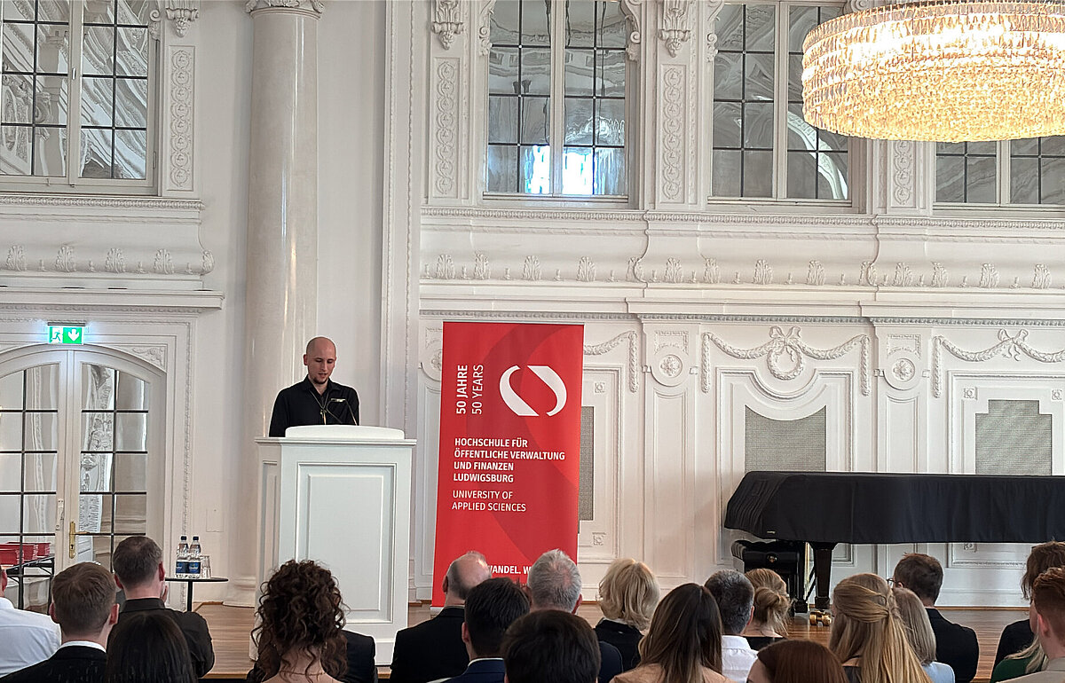 Jahrgangssprecher Nikolai Ziereisen bei seiner Rede zur Bachelorfeier der Steuerverwaltung im Weißen Saal des Neuen Schlosses in Stuttgart.