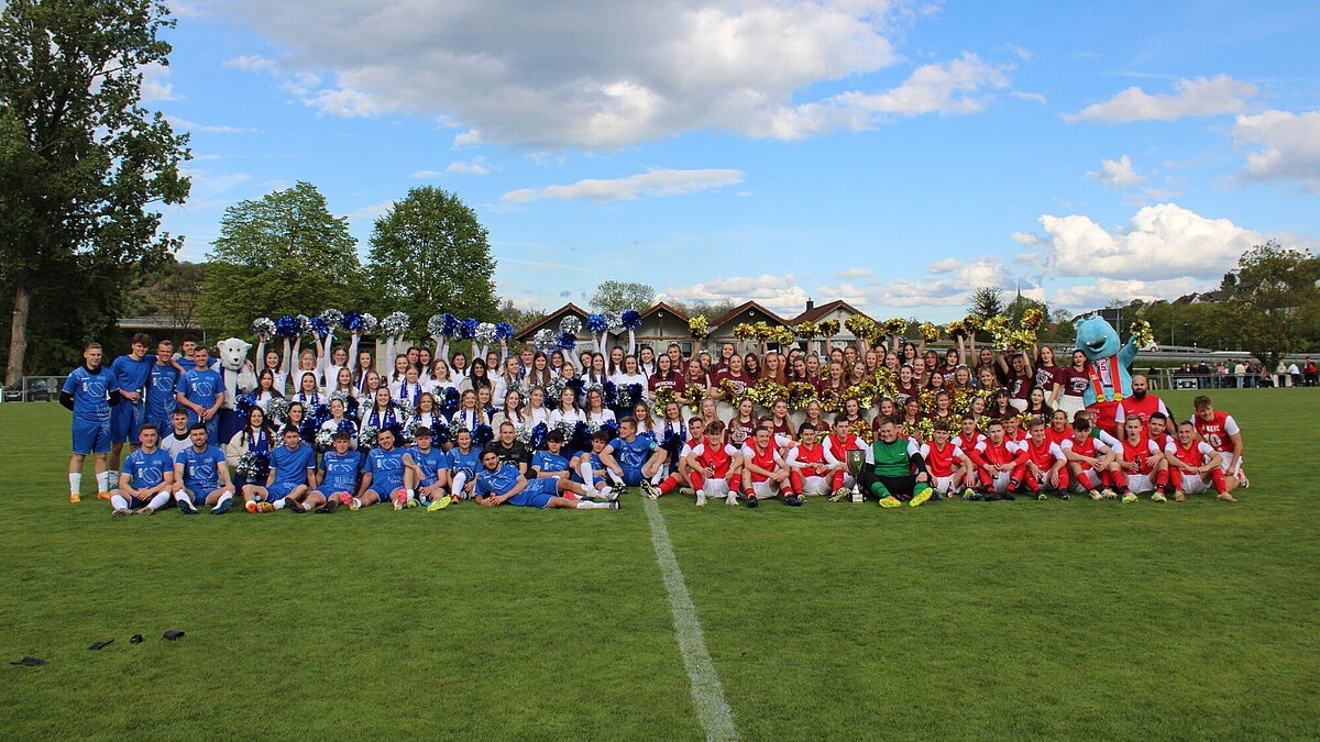 Fußballer und Cheerleader der HVF Ludwigsburg und der HS Kehl sowie die Hochschulmaskottchen auf einem Fußballfeld