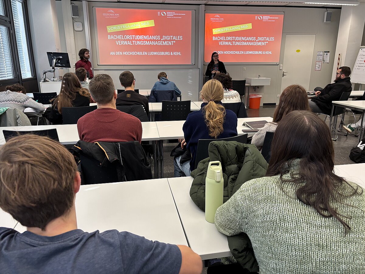 Mitarbeiterin und Student stellen den Studiengang Digitales Verwaltungsmanagement vor.